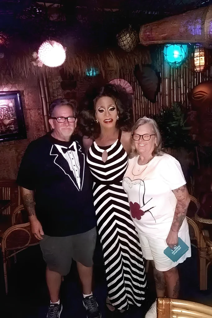 Toni James standing between two people at an indoor event