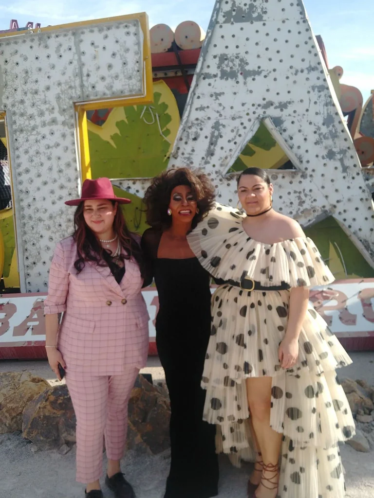 Toni James standing with two people beside large illuminated letters
